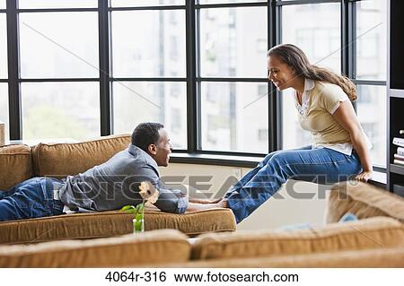 Stock Photograph - Couple relaxing in loft apartment. Fotosearch
