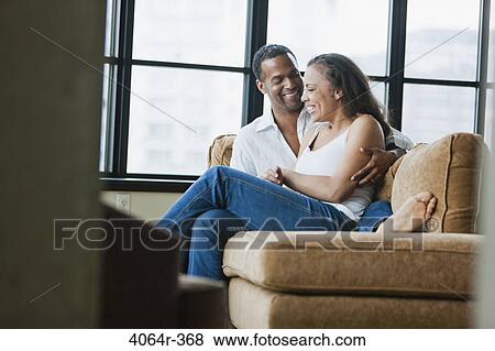 Couple relaxing on couch in loft apartment View Large Photo Image Stock Photo - Couple relaxing on couch in loft apartment. Fotosearch