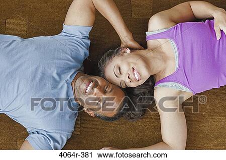 Stock Image - Couple relaxing on floor. Fotosearch