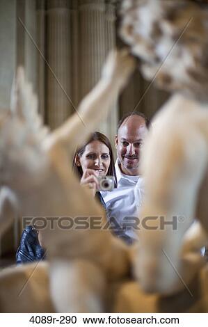 Couple taking picture of a statue in a museum View Large Photo Image Stock Image - Couple taking picture of a statue in a museum. Fotosearch