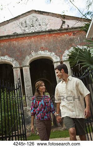 Couple walking in front of a building, Mexico View Large Photo Image Stock Photograph - Couple walking in front of a building, Mexico. Fotosearch