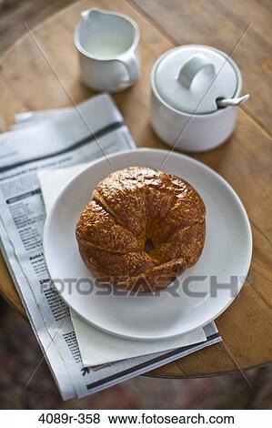 Croissant and newspaper on wooden table, still life View Large Photo Image Stock Photo - Croissant and newspaper on wooden table, still life. Fotosearch
