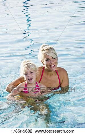 Cute little girl and mom having fun in pool View Large Photo Image Stock Image - Cute little girl and mom having fun in pool. Fotosearch