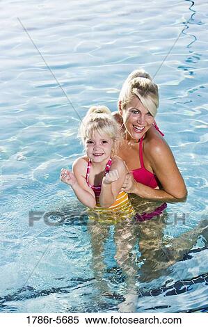 Stock Photography - Cute little girl and mom having fun in pool. Fotosearch