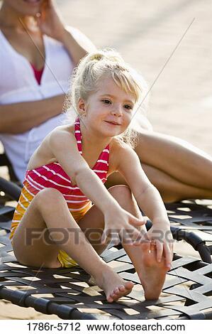 Cute little girl sitting in lounge chair View Large Photo Image Stock Image - Cute little girl sitting in lounge chair. Fotosearch