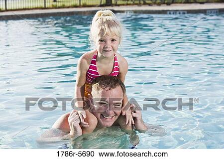 Stock Image - Dad and his little girl playing in swimming pool. Fotosearch