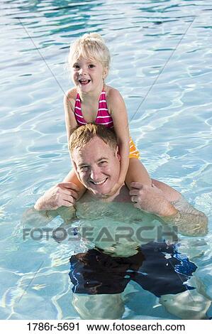 Stock Image - Dad and his little girl playing in swimming pool. Fotosearch