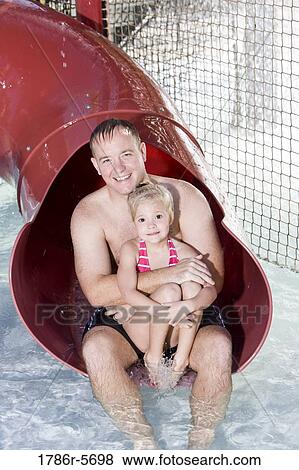 Dad and little girl sitting on water slide View Large Photo Image Stock Photo - Dad and little girl sitting on water slide. Fotosearch
