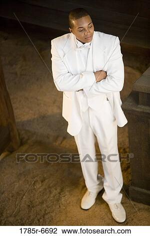 Elevated view of a groom in a white tuxedo with arms folded View Large Photo Image Stock Image - Elevated view of a groom in a white tuxedo with arms folded. Fotosearch