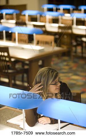 Elevated view of a young woman sitting in the reading room of a library View Large Photo Image Stock Photo - Elevated view of a young woman sitting in the reading room of a library. Fotosearch