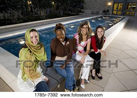 Elevated view of four women friends smiling, sitting by fountain View Large Photo Image Stock Image - Elevated view of four women friends smiling, sitting by fountain. Fotosearch