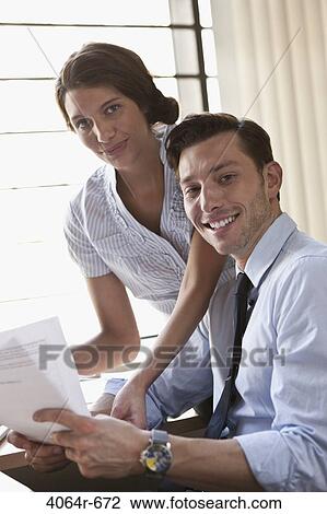 Employees collaborating at desk in office View Large Photo Image Stock Image - Employees collaborating at desk in office. Fotosearch