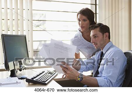 Employees collaborating at desk View Large Photo Image Stock Image - Employees collaborating at desk. Fotosearch