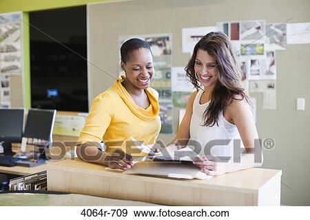 Employees collaborating at office View Large Photo Image Stock Photo - Employees collaborating at office. Fotosearch