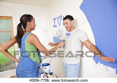 Expectant couple goofing off while painting nursery View Large Photo Image Stock Image - Expectant couple goofing off while painting nursery. Fotosearch