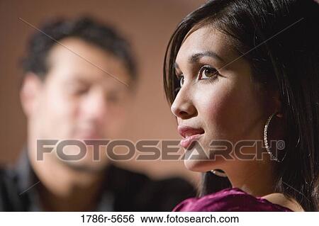 Face of beautiful woman, man in background View Large Photo Image Stock Photograph - Face of beautiful woman, man in background. Fotosearch