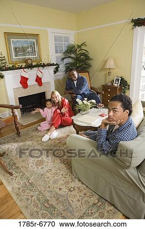 Family in pajamas sitting by fireplace decorated for Christmas View Large Photo Image Stock Image - Family in pajamas sitting by fireplace decorated for Christmas. Fotosearch