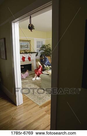 Family in pajamas sitting by fireplace decorated for Christmas View Large Photo Image Stock Photo - Family in pajamas sitting by fireplace decorated for Christmas. Fotosearch
