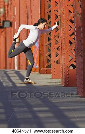 Female jogger, stretching on bridge View Large Photo Image Stock Image - Female jogger, stretching on bridge. Fotosearch