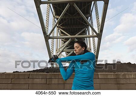 Stock Image - Female urban athlete stretching. Fotosearch