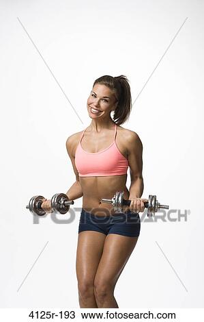 Fitness woman smiling doing dumbell curls in studio View Large Photo Image Stock Image - Fitness woman smiling doing dumbell curls in studio. Fotosearch