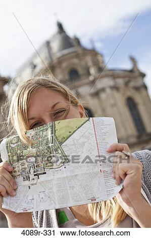 Stock Image - France, Ile-De-France, Paris, Versailles, Teenage girl holding map at Chateau De Versailles. Fotosearch