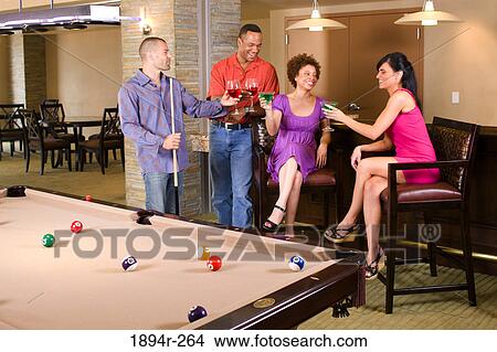 Picture - Friends having drinks in the bar of a tourist resort. Fotosearch