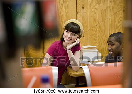 Friends having lunch in a diner View Large Photo Image Stock Image - Friends having lunch in a diner. Fotosearch