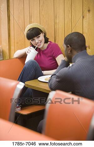 Friends having lunch in a diner View Large Photo Image Stock Photograph - Friends having lunch in a diner. Fotosearch
