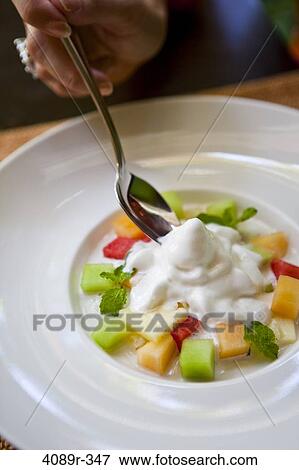Stock Photo - Fruit salad dessert with whipped cream. Fotosearch