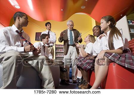 Group of high school students in library with teacher View Large Photo Image Stock Image - Group of high school students in library with teacher. Fotosearch