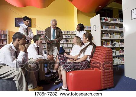 Group of high school students in library with teacher View Large Photo Image Stock Image - Group of high school students in library with teacher. Fotosearch