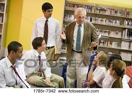 Group of high school students in library listening to teacher View Large Photo Image Stock Image - Group of high school students in library listening to teacher. Fotosearch