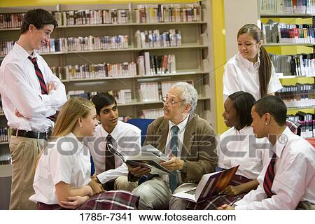 Group of high school students reading in library with teacher View Large Photo Image Stock Image - Group of high school students reading in library with teacher. Fotosearch