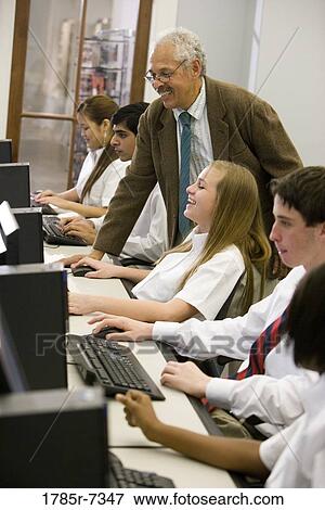 Group of high school students with their teacher in a computer lab View Large Photo Image Stock Photo - Group of high school students with their teacher in a computer lab. Fotosearch