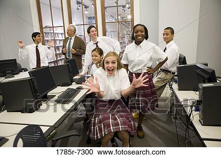 Group of teenage boy and girl students in school uniforms with teacher in a computer lab View Large Photo Image Stock Image - Group of teenage boy and girl students in school uniforms with teacher in a computer lab. Fotosearch