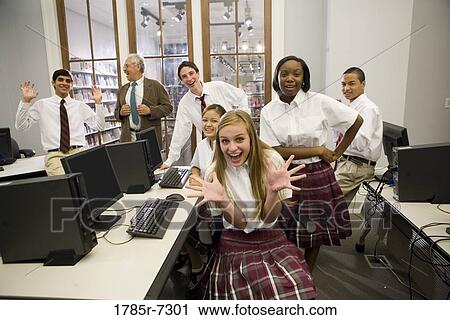 Group of teenage boy and girl students in school uniforms with teacher in a computer lab View Large Photo Image Stock Image - Group of teenage boy and girl students in school uniforms with teacher in a computer lab. Fotosearch