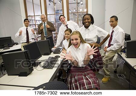 Group of teenage boy and girl students in school uniforms with teacher in a computer lab View Large Photo Image Stock Image - Group of teenage boy and girl students in school uniforms with teacher in a computer lab. Fotosearch