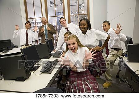 Group of teenage boy and girl students in school uniforms with teacher in a computer lab View Large Photo Image Stock Image - Group of teenage boy and girl students in school uniforms with teacher in a computer lab. Fotosearch