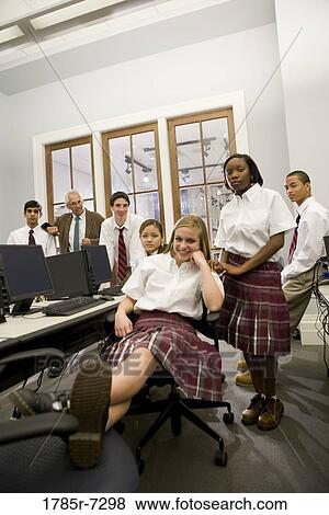 Group of teenage boy and girl students in school uniforms with teacher in a computer lab View Large Photo Image Stock Photo - Group of teenage boy and girl students in school uniforms with teacher in a computer lab. Fotosearch