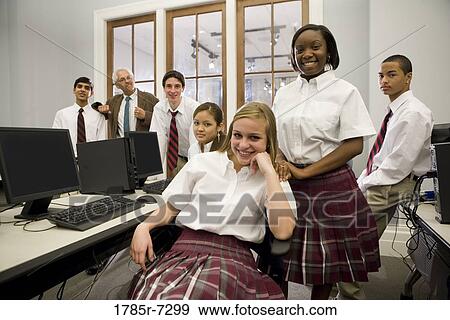 Group of teenage boy and girl students in school uniforms with teacher in a computer lab View Large Photo Image Stock Photo - Group of teenage boy and girl students in school uniforms with teacher in a computer lab. Fotosearch