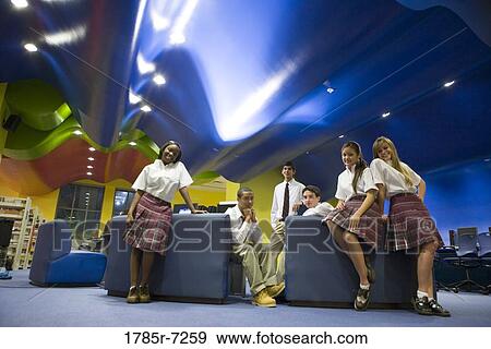 Stock Photo - Group of teenage students hanging out in lounge area of library. Fotosearch