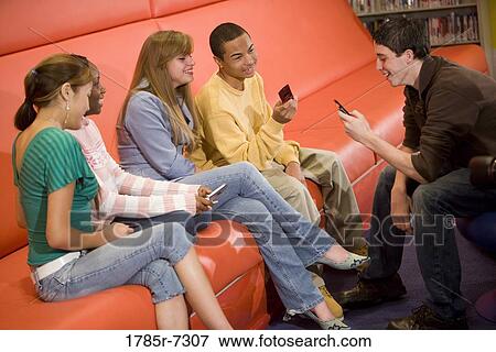 Group of teenagers using their cellphones View Large Photo Image Stock Photo - Group of teenagers using their cellphones. Fotosearch