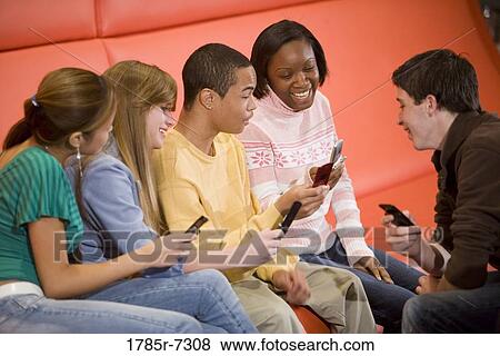Group of teenagers using their cellphones View Large Photo Image Stock Photo - Group of teenagers using their cellphones. Fotosearch