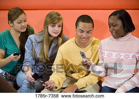 Group of teenagers with their cellphones View Large Photo Image Stock Photo - Group of teenagers with their cellphones. Fotosearch