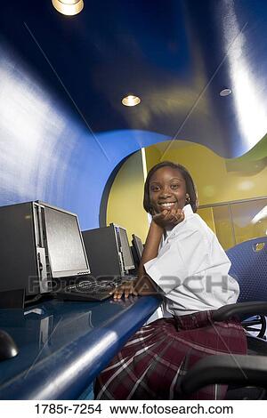 High school student wearing a uniform sitting alone in a computer lab View Large Photo Image Picture - High school student wearing a uniform sitting alone in a computer lab. Fotosearch