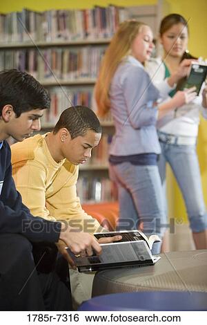 Stock Photograph - High school students reading in library. Fotosearch