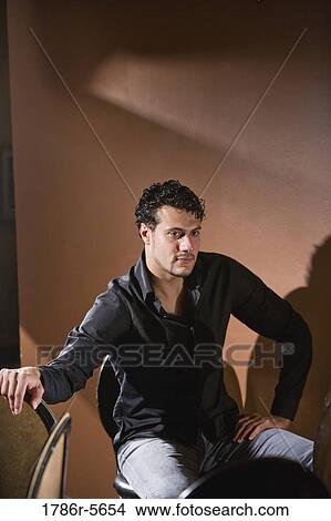 Hispanic man sitting alone on bar stool thinking View Large Photo Image Picture - Hispanic man sitting alone on bar stool thinking. Fotosearch