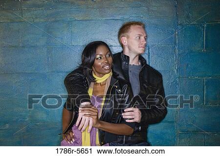 Interracial couple leaning against grungy blue wall View Large Photo Image Stock Image - Interracial couple leaning against grungy blue wall. Fotosearch