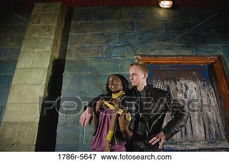 Interracial couple standing by grungy doorway View Large Photo Image Stock Photo - Interracial couple standing by grungy doorway. Fotosearch